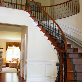 A beautifully designed staircase with a wooden railing leading to an elegant living space.