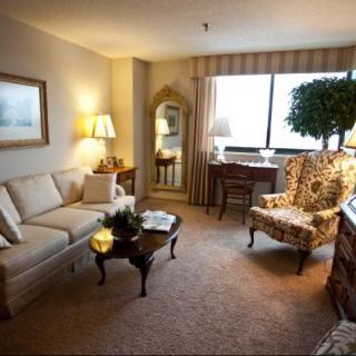 A cozy living room with traditional decor featuring a sofa, armchair, and coffee table.