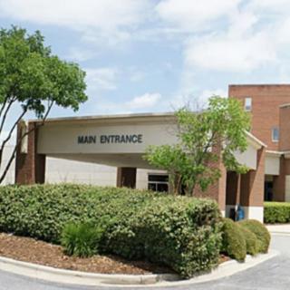 The main entrance of a healthcare facility surrounded by greenery.