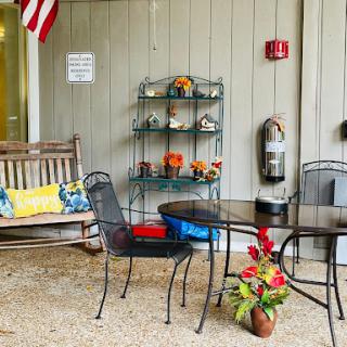 A cozy outdoor seating area with a swing and decorative plants, perfect for relaxation.