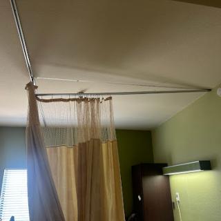 A hospital room featuring a privacy curtain hanging from a ceiling track.