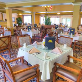 A well-appointed dining room featuring neatly set tables and comfortable seating.