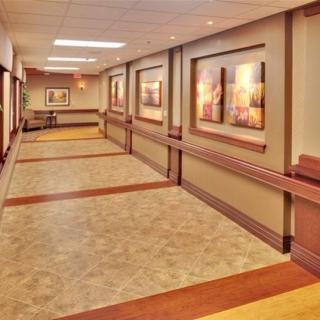 A well-lit hallway with framed artwork on the walls.