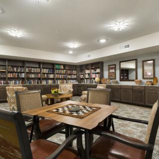A cozy library with bookshelves, tables, and seating for reading.