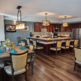 A modern open-concept kitchen and dining area featuring elegant lighting and stylish furniture.