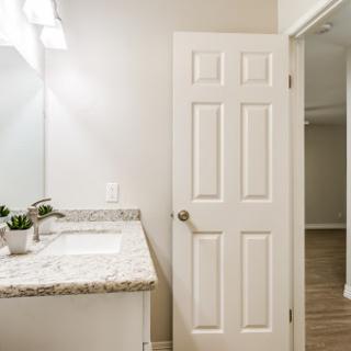 A modern bathroom featuring a stylish vanity with a sink, illuminated by soft lighting.