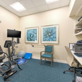 A physical therapy room equipped with various exercise machines and tools for rehabilitation.
