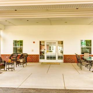 An inviting building entrance with outdoor seating under a covered patio.