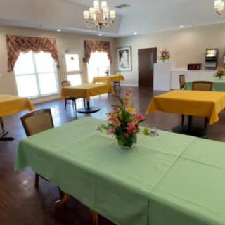 A tidy dining room with colorful tablecloths and floral centerpieces.