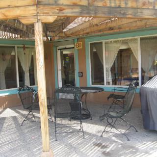 A cozy outdoor patio area with furniture under a pergola.