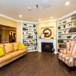 A cozy living room featuring a fireplace, bookshelves filled with books, and comfortable seating.