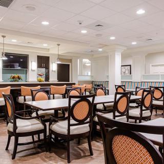 A well-lit dining area with neatly arranged tables and chairs, featuring a modern interior design.