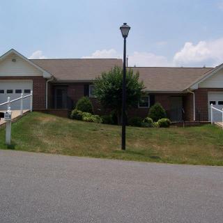 A suburban house with a driveway and garages on a sunny day.