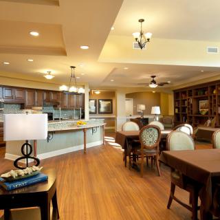 A spacious open-plan kitchen and dining area with elegant lighting and wooden flooring.