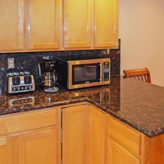 A modern kitchen countertop with a microwave, toaster, and coffee maker.