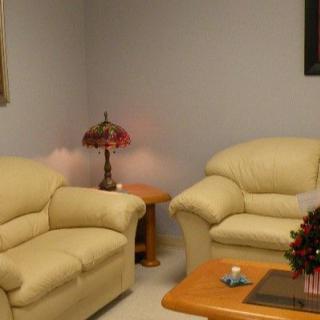 A cozy living room with cream-colored sofas, a wooden coffee table, and a decorative lamp on a side table.