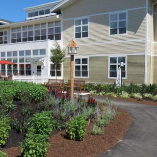 A well-maintained garden with a pathway leading to a residential building.