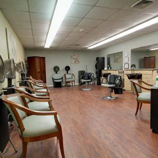 An interior view of a hair salon featuring chairs, mirrors, and other salon equipment.