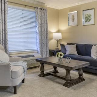 A cozy living room with a sofa, armchair, and coffee table.