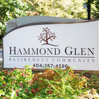 Sign for Hammond Glen Retirement Community surrounded by greenery.