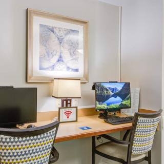 A cozy workstation with dual monitors and a decorative lamp on the desk.