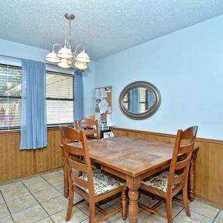 A cozy dining room with wooden furniture and a chandelier.