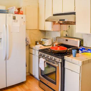 A home kitchen with a refrigerator, stove, and cabinetry.