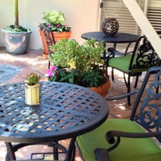 A cozy outdoor patio setting with metal furniture and potted plants.