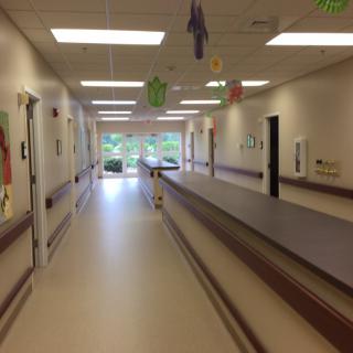 A hospital hallway with bright lighting and medical equipment access.