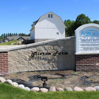 Welcome to Alexia Farm, a picturesque rural landscape featuring a charming barn and welcoming signage.