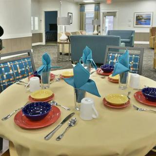A neatly arranged dining table with colorful plates and decorative napkins in an inviting indoor setting.