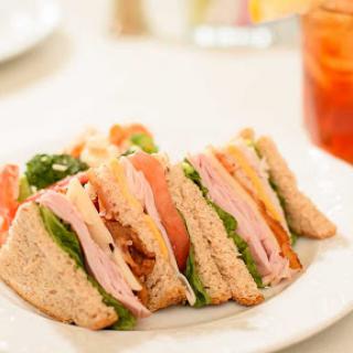 A deliciously stacked sandwich featuring turkey, fresh vegetables, and whole grain bread.