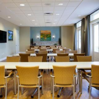 A well-lit conference room setup with chairs and tables arranged for a meeting or presentation.