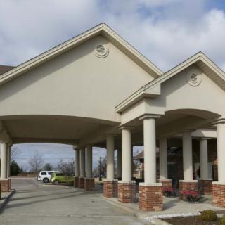 A building entrance with a covered driveway and columns.