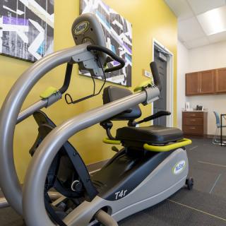 A modern exercise machine in a gym setting with yellow walls and contemporary decor.