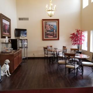 A cozy hotel lobby cafe area with seating, a coffee station, and decorative elements.