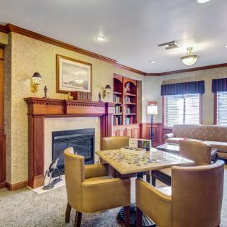 A cozy living room featuring a fireplace, bookshelves, and comfortable seating.