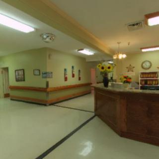 A hospital reception area with a hallway and desk.