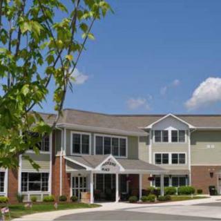 A well-maintained senior living facility with a welcoming entrance and greenery.