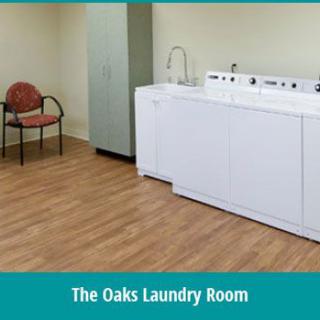 A clean and simple laundry room with washing machines and a chair.