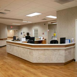 A hospital reception area with a nurse station and computers.