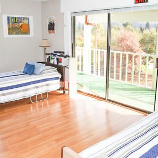 A bright and airy bedroom with two beds and a balcony view.