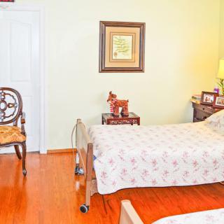 A cozy bedroom with a bed, wheelchair, and decor.