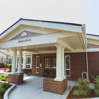 The exterior view of a building entrance with a covered porch and pillars.