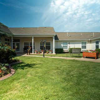 A view of a residential building with a well-maintained lawn and garden.
