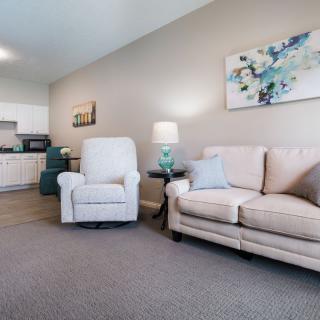 A cozy living room with a sofa, armchair, and modern decor.