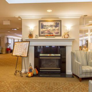 A cozy living space with a fireplace, artwork, and autumn decorations.