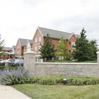 A scenic view of a residential building surrounded by trees and landscaping.