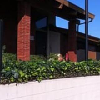 A brick building with plants and a clear blue sky.