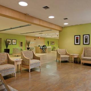 A modern lobby area with green walls and comfortable seating.